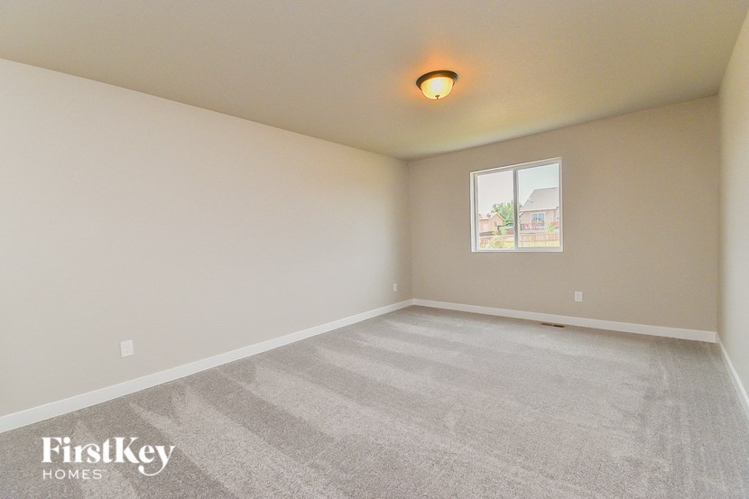 the spacious living room with carpeting and a window
