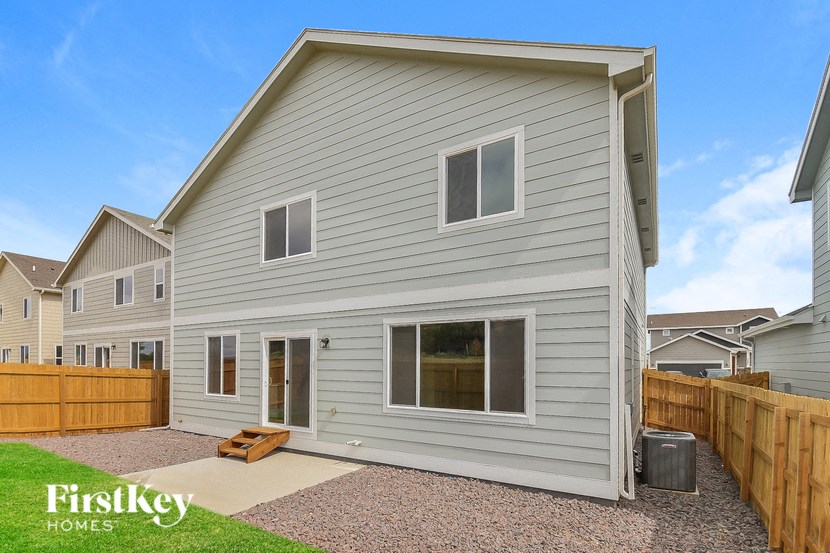 a white house with a yard and a wooden fence