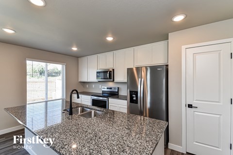A kitchen with granite countertops and stainless steel appliances.