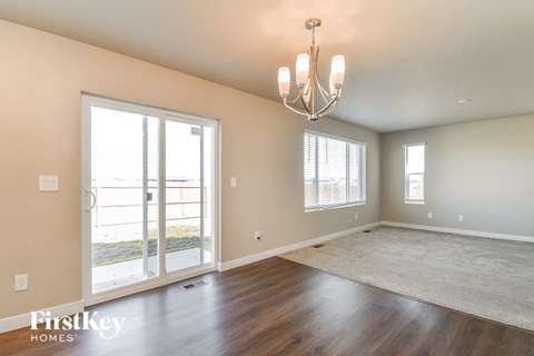 A room with a chandelier, a carpet, and a sliding glass door.