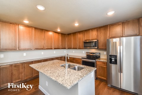 A kitchen with wooden cabinets and a granite countertop.