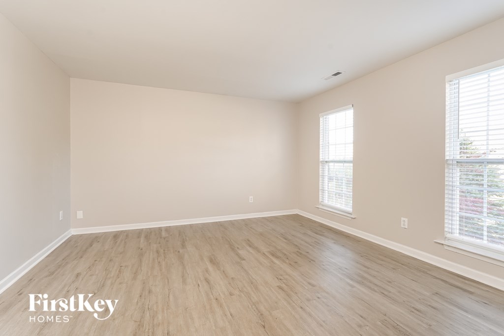 a spacious living room with wood floors and white walls
