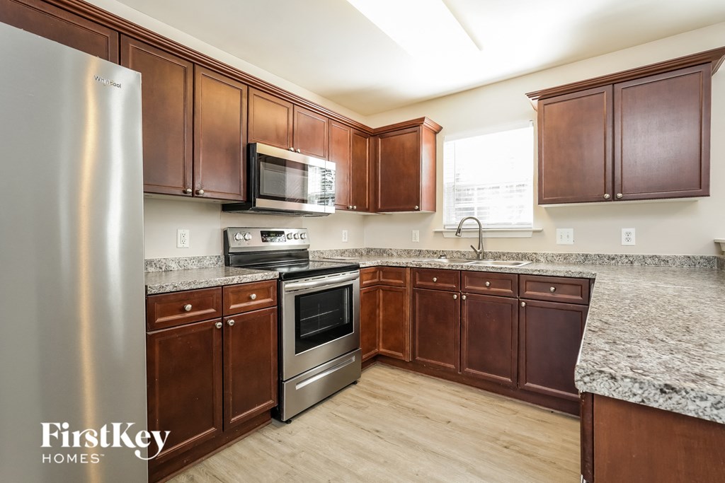 a kitchen with wood cabinets and granite counter tops and stainless steel appliances