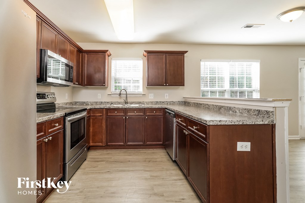 a kitchen with wooden cabinets and stainless steel appliances and granite counter tops
