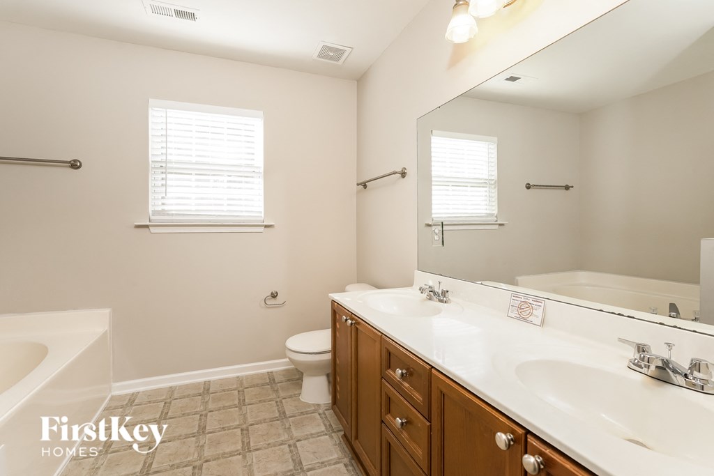a bathroom with two sinks and a tub and a toilet