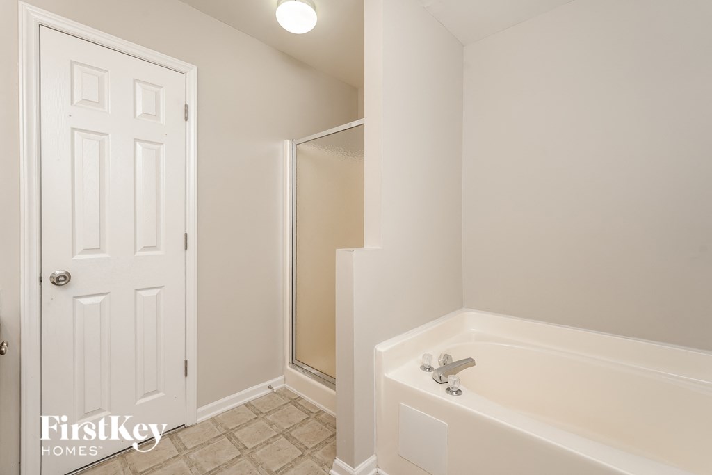 a white bathroom with a tub and a shower