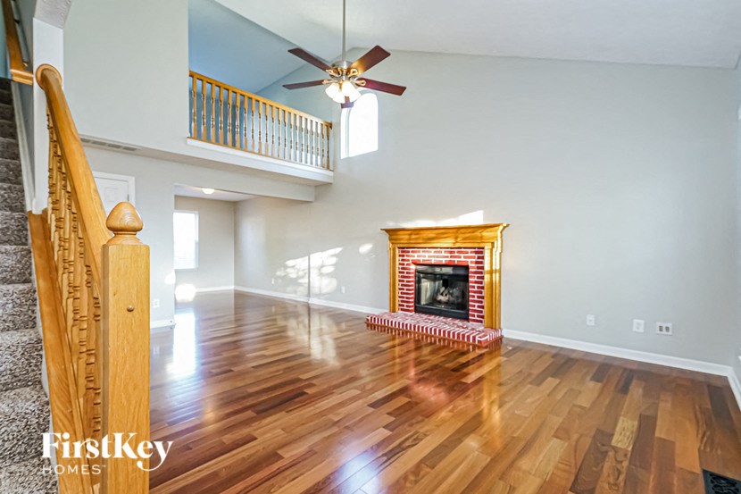a living room with a fireplace and a ceiling fan