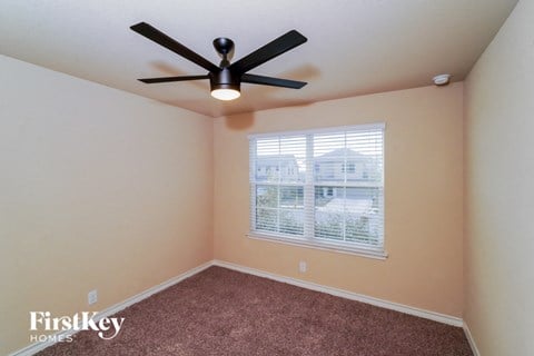 a bedroom with a ceiling fan and a window
