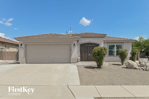 A house with a garage and a driveway in front of it.