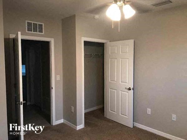 an empty room with a white door and a ceiling fan