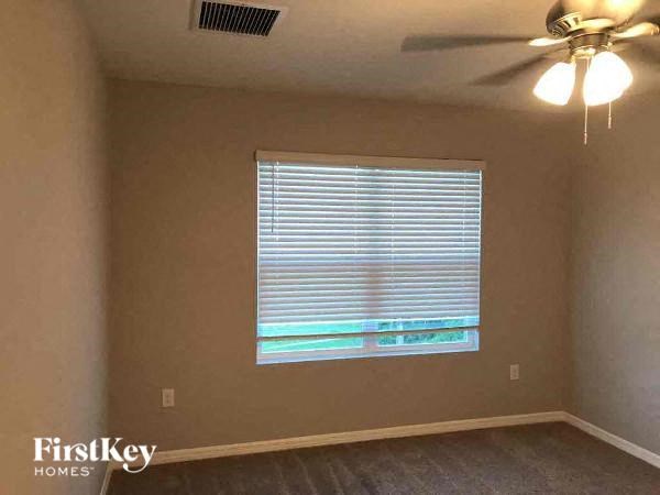 a living room with a window and a ceiling fan