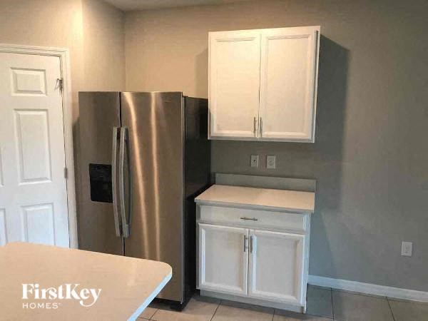 a kitchen with a stainless steel refrigerator and white cabinets