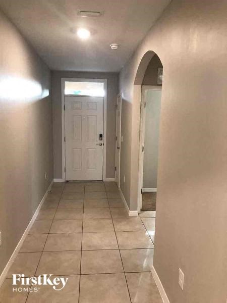 a hallway with a tiled floor and a white door