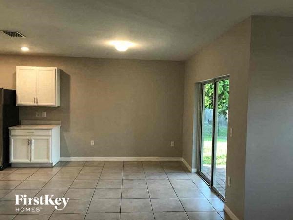 a living room with a kitchen and a sliding glass door