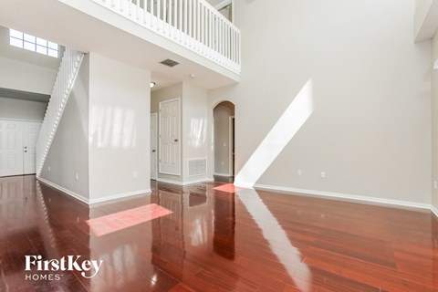 an empty living room with wood floors and white walls