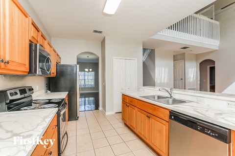 a kitchen with marble counter tops and wooden cabinets and a sink