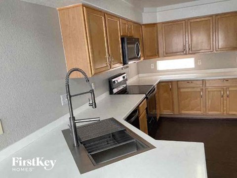 A kitchen with wooden cabinets and a stainless steel sink.