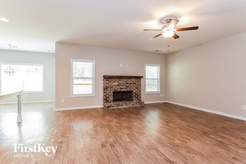 a living room with a fireplace and a ceiling fan