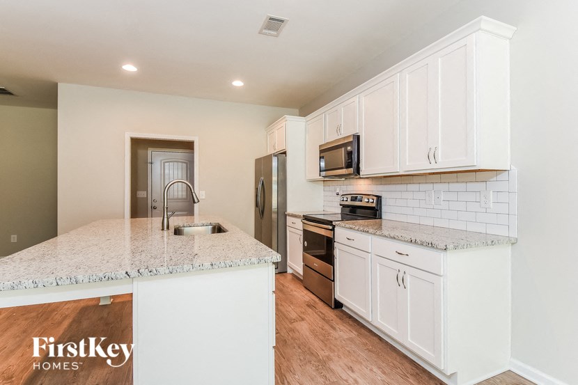 a kitchen with white cabinets and a counter top