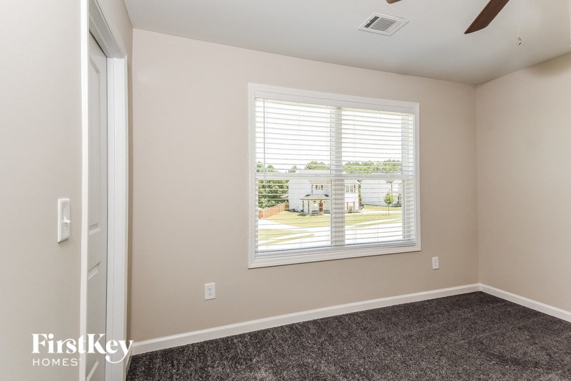 a room with a large window and a carpeted floor