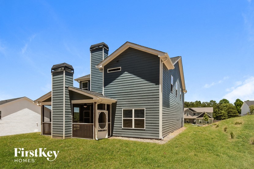 a blue house with a porch and a grassy yard