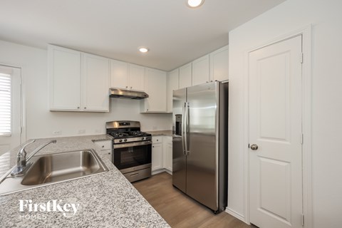 A kitchen with a stainless steel refrigerator and a sink.