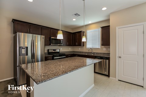 A kitchen with granite countertops and stainless steel appliances.