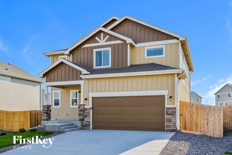 a tan and brown house with a garage door