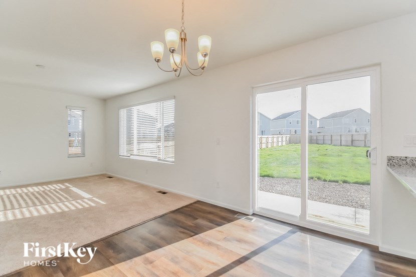 an empty living room with a sliding glass door to a yard