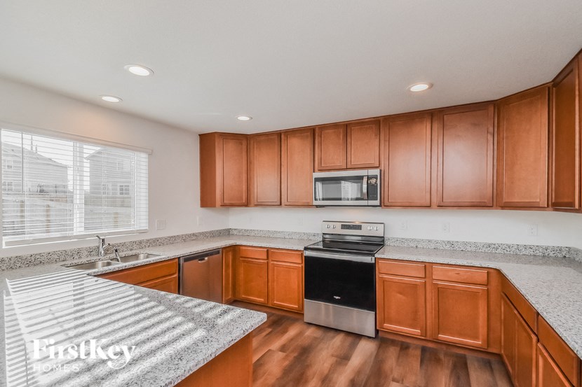 a kitchen with wood cabinets and granite counter tops and a sink