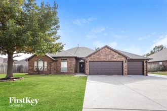 front view of a brick house with a driveway and a tree