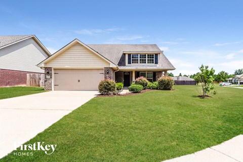 A house with a garage and a driveway in front of it.