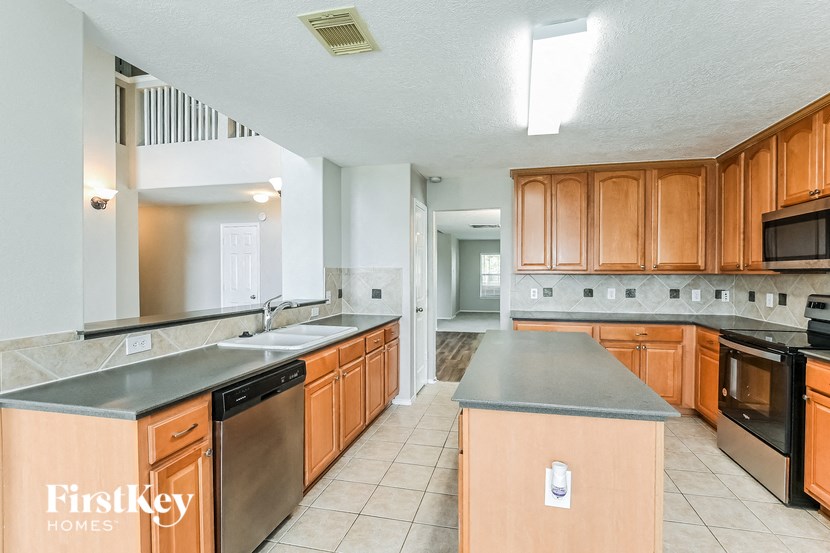 a large kitchen with wooden cabinets and stainless steel appliances