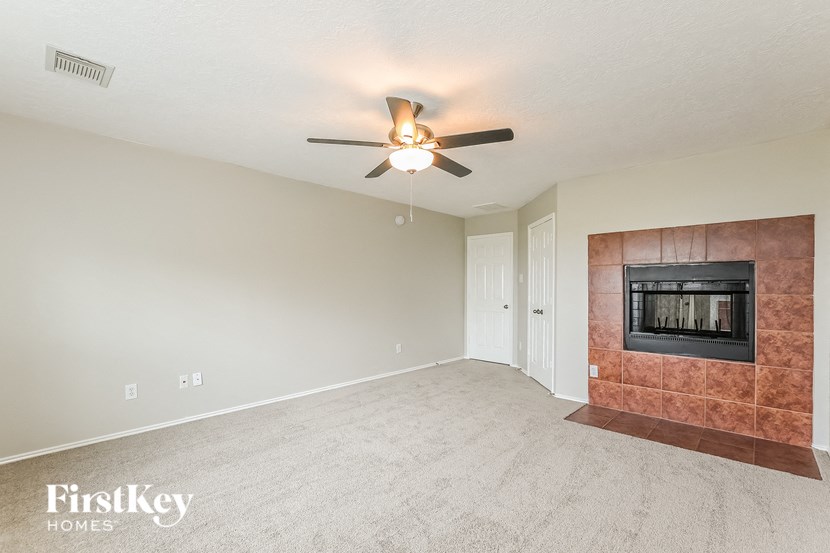 a living room with a fireplace and a ceiling fan