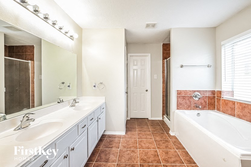 a large bathroom with a tub and a sink and a mirror