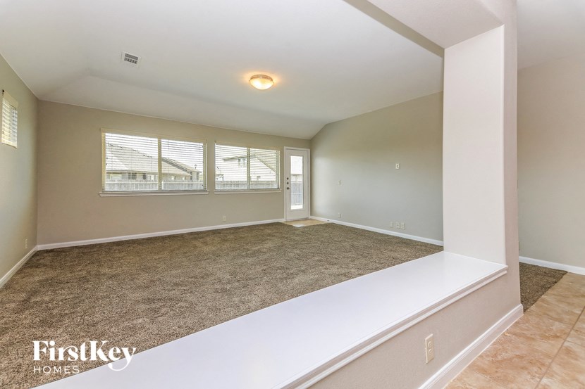 an empty living room with a white couch and a window