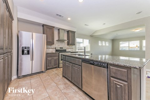 a large kitchen with stainless steel appliances and granite counter tops