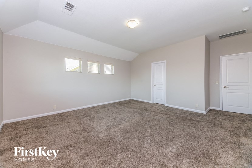 an empty living room with carpet and two doors