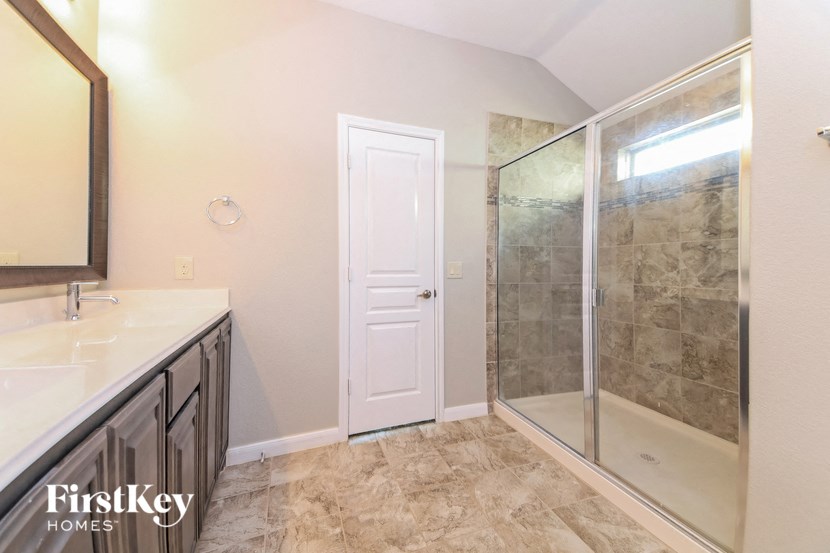 a bathroom with a shower and a sink and a mirror