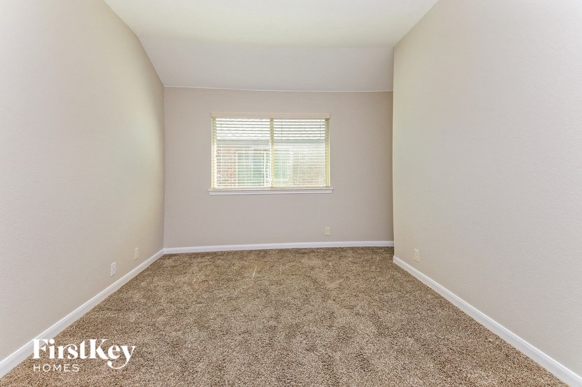 an empty room with carpet and a window