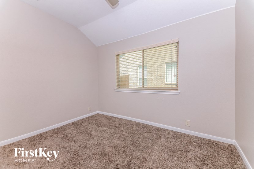 an empty room with a window and carpet