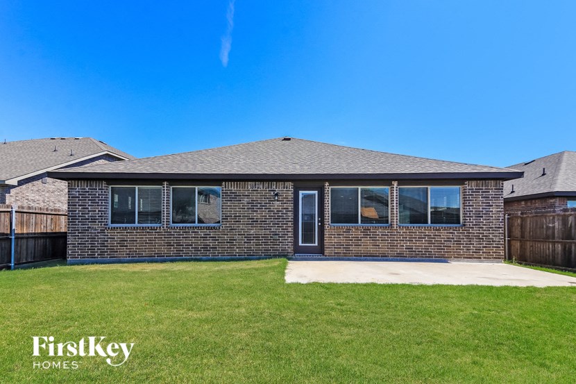 a brick house with a yard and a blue sky