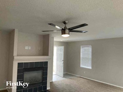 a living room with a ceiling fan and a fireplace