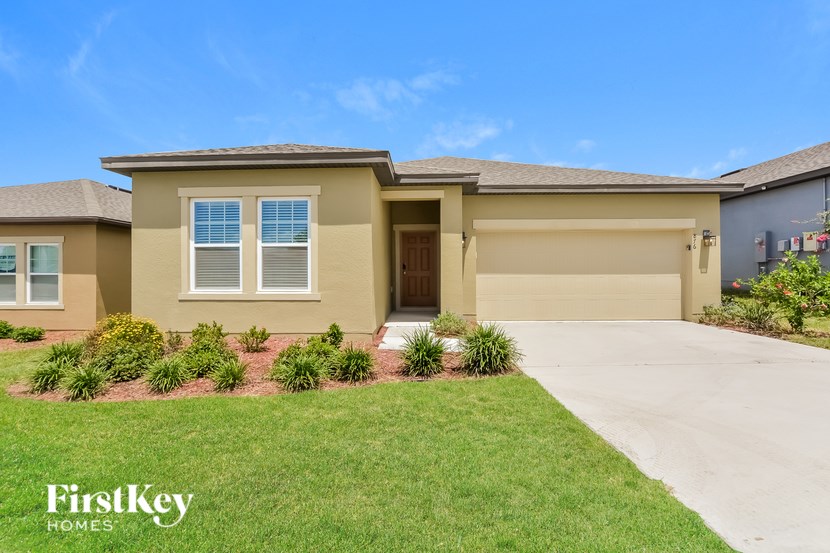 A house with a garage and a driveway in front of it.
