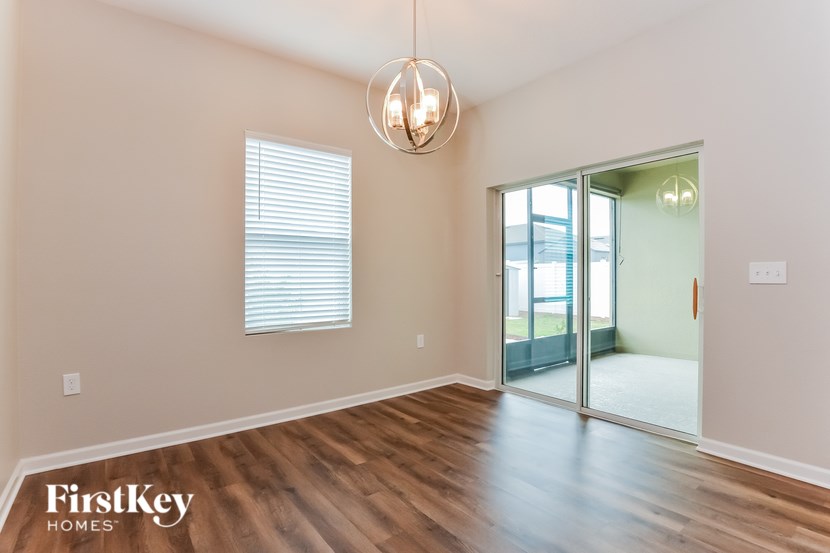 A room with wooden floors and a sliding glass door leading to a balcony.