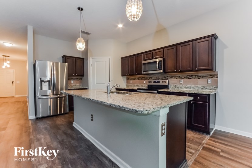 A kitchen with a granite countertop and a refrigerator.