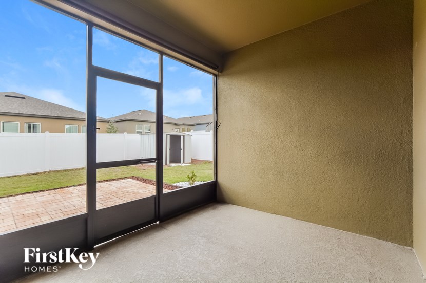 A room with a view of a house and a clear sky through the window.