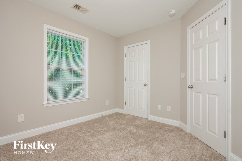 the bedroom of a home with a carpeted floor and a white door
