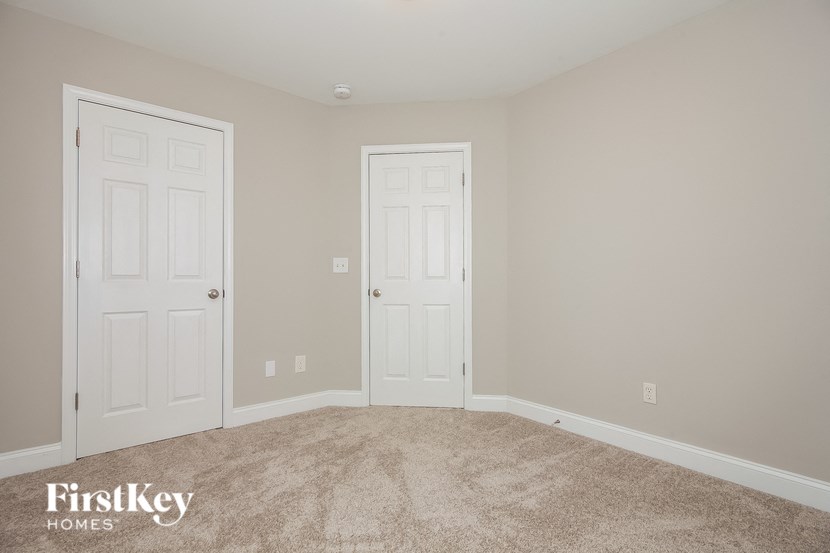 a bedroom with two doors and a carpeted floor