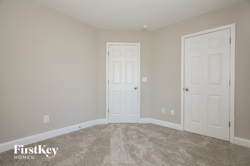 a bedroom with two doors and a carpeted floor